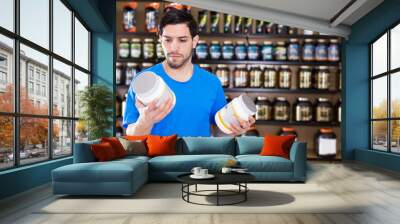 sport man looking different sport nutrition products Wall mural