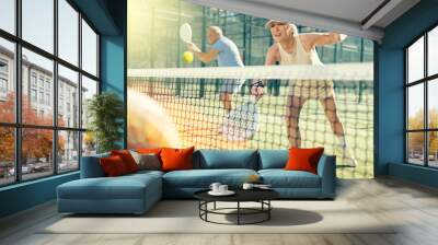 Sportive elderly man and woman engaged in Padel Tennis in open-air court of tennis club Wall mural