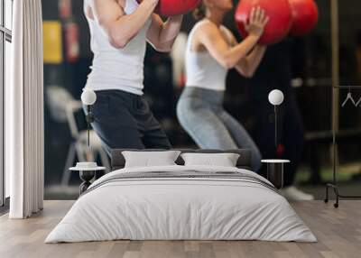 Sportive young man training with weight ball in sports hall during crossfit workout Wall mural