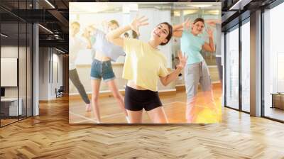 Teenagers in dance hall studying new movements, smiling and having fun Wall mural