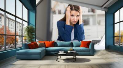 Tired young businesswoman working with documents in office Wall mural