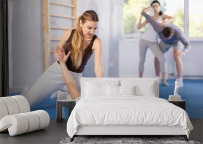 Trained young girl twisting her opponent's arm during self-defense classes Wall mural