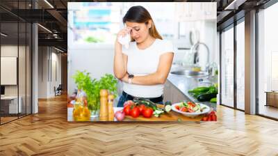 Unhappy mexican housewoman crying during cooking in kitchen Wall mural