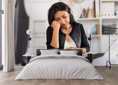 Upset peruvian business woman crying at her workplace in modern office.. Wall mural