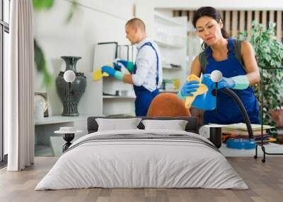 Woman and man in uniform, workers from cleaning service, wiping office with cloth and liquid Wall mural