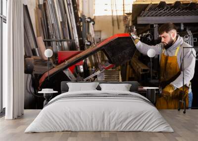 Worker cuts metal profile pipe on a band saw. High quality photo Wall mural