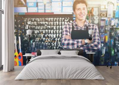 worker in hardware store trading goods for water tap in uniform Wall mural