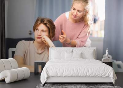 Worried mother trying to talk to upset teenage son at home. Concept of communication difficulties in adolescence Wall mural