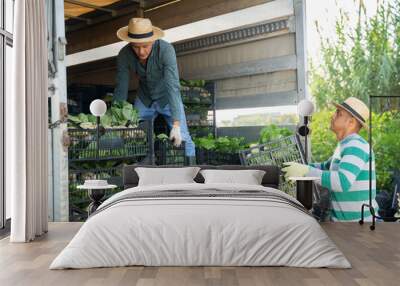 Young adult male driver helping farmer to load crates with gathered bok choy cabbage into lorry Wall mural