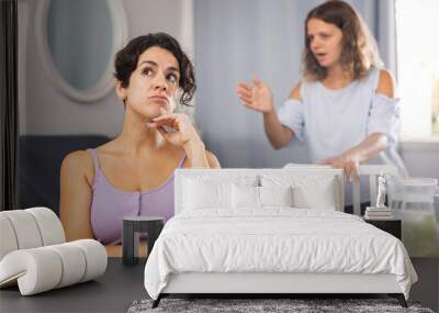 Young adult woman feeling bored during home conflict and ignoring her female partner trying to talk, LGBT lesbian couple having problems in relationship Wall mural