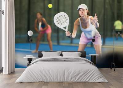 Young and adult women in doubles play tennis on tennis court Wall mural