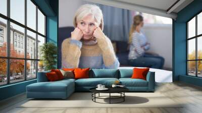 Young daughter angry with elderly mother at home Wall mural