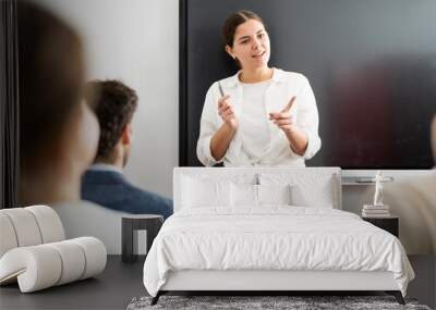 Young female professor explaining subject to classroom full of students Wall mural