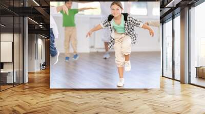 Young girl and group of positive children practicing energetic hip hop movements at modern dance school Wall mural