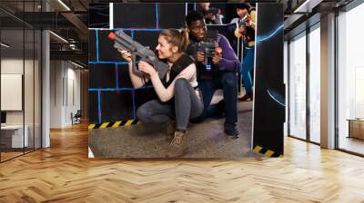 Young man and woman playing laser tag Wall mural