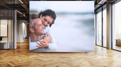 A beautiful couple in their forties  walks on the beach Wall mural