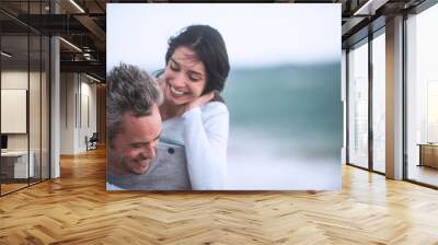 A beautiful couple in their forties  walks on the beach Wall mural