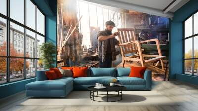 A craftsman in his workshop working on an armchair frame  Wall mural