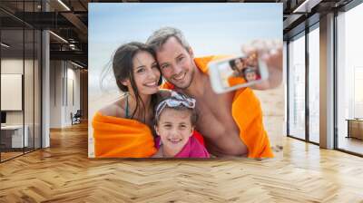 A young couple and their daughter taking a selfie Wall mural