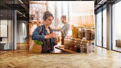 Beautiful young woman shopping in a bulk food store Wall mural