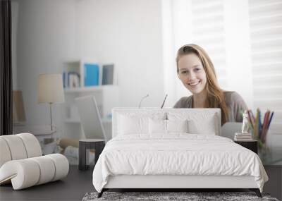 beautiful young woman working on her laptop in her office Wall mural