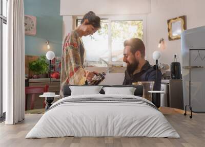 Cheerful couple having breakfast in the kitchen of their house Wall mural