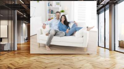 cheerful couple relaxing in sofa at home Wall mural