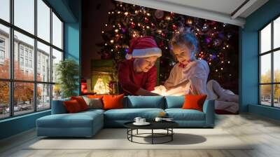 Christmas night. A brother and his sister open their gifts Wall mural