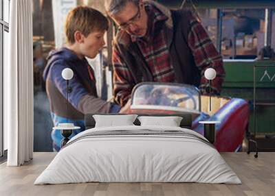 Father and his young son in a DIY workshop to repair a pedal car Wall mural