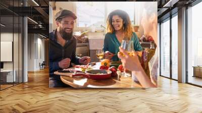 Mixed group of friends having fun while cooking lunch in kitchen Wall mural