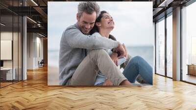 Portrait of a middle-aged couple sitting on the beach Wall mural