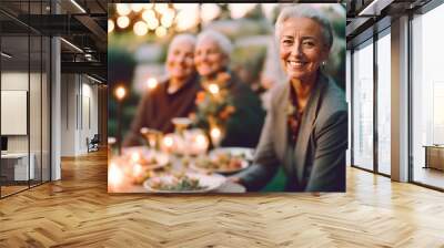 seniors gathered around a table in the garden. A beautiful senior woman smiles at the camera Wall mural