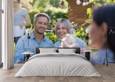 summer. Group of friends gathered around a table in the garden Wall mural