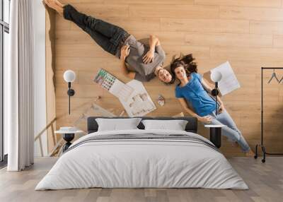 Top view, a modern couple lying on the floor of their new home Wall mural