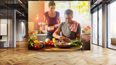 trendy couple cooking vegetables from the market in the kitchen Wall mural