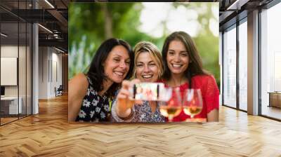 TThree beautiful women having fun by taking a selfie Wall mural