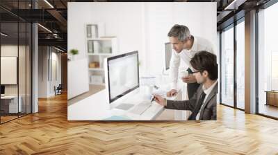 two colleagues speaks about business at office in front of compu Wall mural