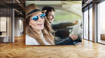 Young couple in his car, happy to drive on a country road Wall mural