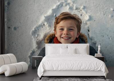 A cheerful and joyful kid lies in the snow and smiles, winter playground Wall mural