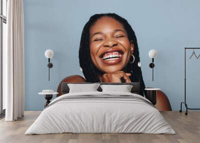 African woman with face piercings smiling cheerfully in a studio Wall mural