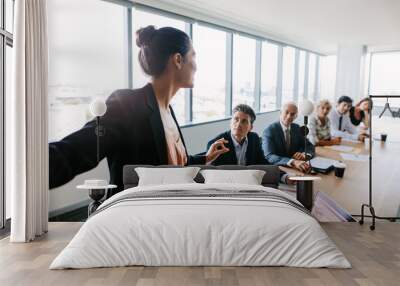 Asian businesswoman giving presentation to coworkers Wall mural