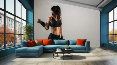 Athletic woman lifting chrome weights Wall mural