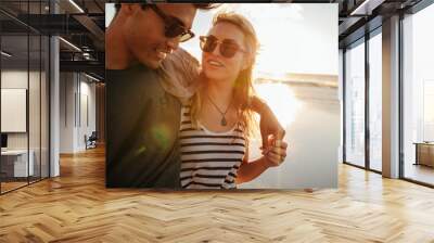 Beautiful woman with her boyfriend on the beach Wall mural