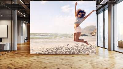 beautiful young woman jumping at the beach Wall mural