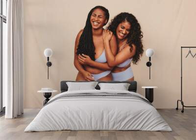 Best friends embracing their natural bodies in a studio Wall mural