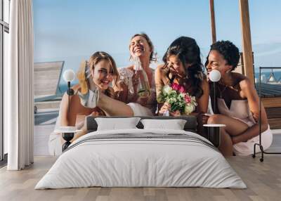 Bride and bridesmaids on rooftop having fun before wedding Wall mural