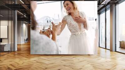 Bride toasting champagne with friends in bridal boutique Wall mural