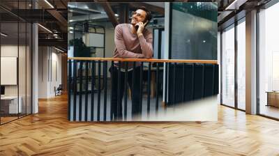 Business man having a conversation on a mobile phone in an office Wall mural