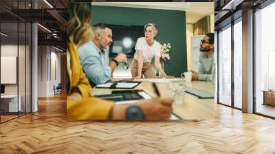 Business manager leading a meeting with her team in a boardroom Wall mural