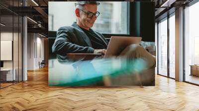 Business professional working on laptop in office lobby Wall mural